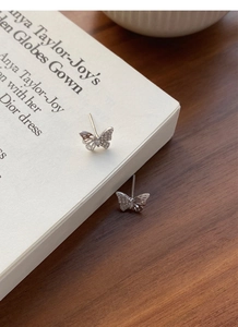 Macro detail of S999 silver butterfly stud earrings with sparkling cubic zirconia inlay