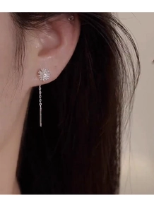 Close-up of elegant S925 sterling silver dandelion tassel earrings on model ear