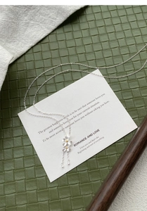 Dettaglio del ciondolo gardenia in argento S999 con petali satinati e nappe a goccia