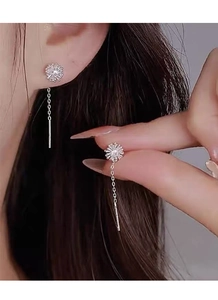 Detail view of S925 sterling silver dandelion tassel earrings on a model with long chain