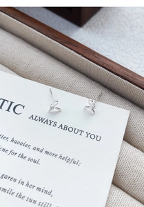 Macro view of S999 sterling silver fishtail stud earrings with tiny zircon insets