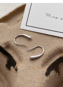 Macro detail of S925 sterling silver teardrop earrings with hallmark on textured card