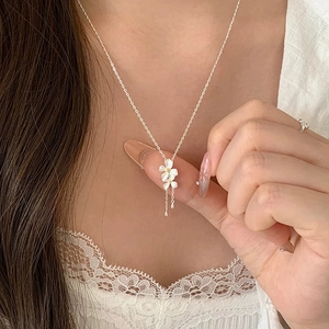 Collana in argento S999 con fiori di gardenia bianchi e nappe delicate su una modella