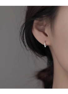 Macro side view of elegant S999 sterling silver teardrop earring worn on a model ear