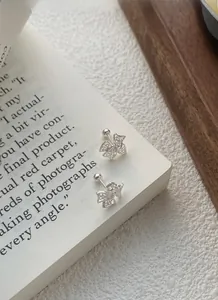 Gros plan sur boucles d'oreilles nœud en argent avec zircons et fermoir à vis sécurisé