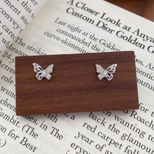 S999 Sterling Silver butterfly stud earrings with sparkling zircons on vintage book background