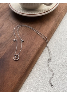 Detailed view of S925 sterling silver moon and star pendant necklace on wooden surface