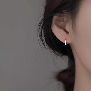 Minimalist S999 sterling silver teardrop stud earrings worn by model on a side view