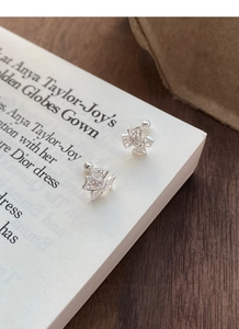 Détail des boucles d'oreilles nœud en argent S999 avec zircons et fermoir à vis sécurisé