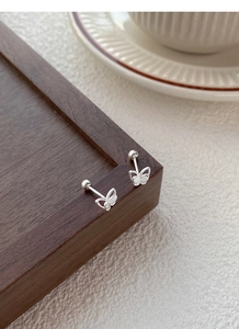 Macro view of double-layered silver butterfly earrings with secure screw back closure