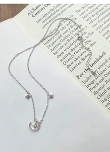 Detailed view of S925 sterling silver moon and star necklace with shimmering cubic zirconia