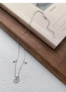Close-up of S925 sterling silver star and moon necklace on a wooden jewelry tray