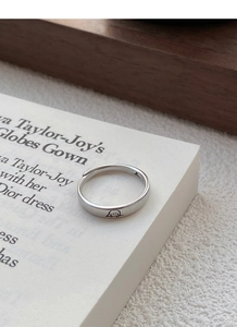 Détail d'une bague réglable en argent S999 avec un dessin de dessin animé minimaliste