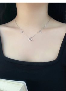 Close-up of S999 silver star and moon necklace with zircon stones on a model
