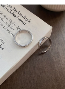 Détail macro de bagues de couple en argent S999 avec gravures de dessins sur un livre