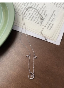 Macro detail of S925 sterling silver moon and star pendant with sparkling cubic zirconia