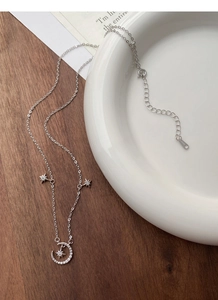 Close-up of S999 sterling silver star and moon pendant with sparkling cubic zirconia