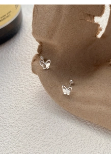 Detailed close-up of 999 sterling silver butterfly studs with secure screw-back design