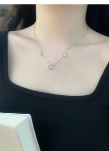 Close-up of S999 sterling silver star and moon necklace on neck with sparkling zircons