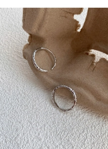 Detailed view of two adjustable silver rings with irregular crinkle texture and hammered finish