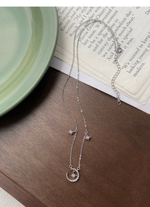 Detail of S999 sterling silver moon and star necklace on elegant lifestyle background