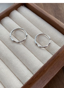 Primo piano di anelli in argento stile bambù in una scatola regalo in legno