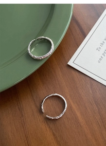 Detailed view of 999 sterling silver rings with hammered texture on a vintage tray