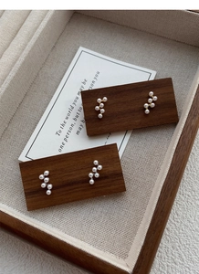 Détail de boucles d'oreilles perles en argent S925 sur un plateau de luxe