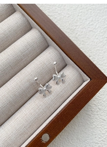 Detail von S999 Silber Schleifenohrringen mit strukturierten Kanten auf Display