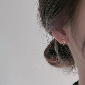 Orecchini a perno minimalisti a serpente in argento sterling S999 indossati da una modella