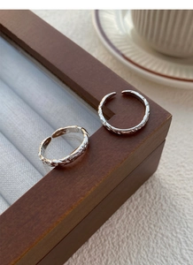 Detail of 999 sterling silver couple rings with textured sugar paper finish on a wood box