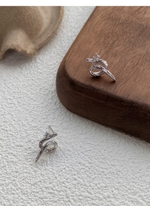 Close-up of S925 sterling silver snake-shaped stud earrings with sparkling cubic zirconia
