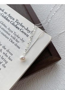 Dettaglio della collana in argento S925 con perla d'acqua dolce su una rivista di moda