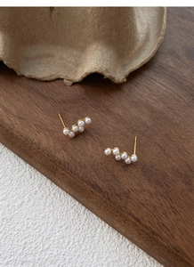 Vue détaillée de cinq perles blanches disposées en vagues sur des boucles d'oreilles S925