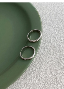 Detailed macro shot of textured sterling silver rings with crumpled paper effect finish