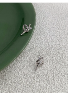 Detailed macro view of S925 silver serpent earrings featuring round clear cubic zirconia
