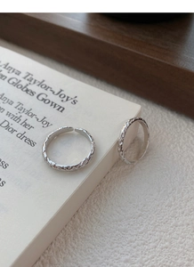 Macro shot of 999 sterling silver rings with irregular lava texture and open adjustable band