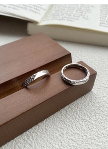 Macro detail of silver adjustable couple rings with irregular molten glacier texture