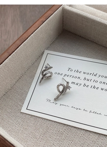 Close-up of S925 sterling silver snake earrings with zircons on a wooden jewelry box