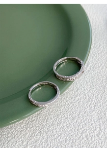 Macro detail of S999 sterling silver adjustable rings with hammered glacial texture surface