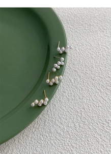 Détail de boucles d'oreilles en argent S925 avec perles en grappe dorées et argentées