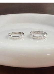 Detail of S999 sterling silver couple rings with unique melted lava texture on white ceramic