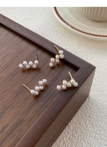 Vue macro de boucles d'oreilles en argent S925 et perles avec un design ondulé minimaliste