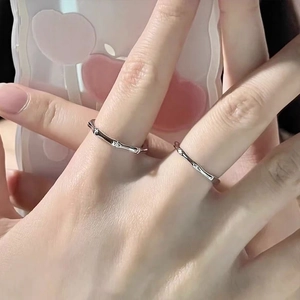 Set di anelli d'argento a bambù con motivo a onde minimalista su mano femminile