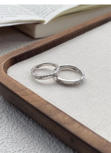 Detailed view of S999 silver rings with hammered texture on a vintage tray and book