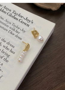 Detail of asymmetric S925 silver earrings with baroque pearls and matte gold finish