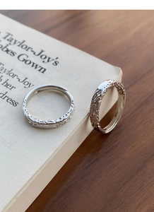 Detail of S999 sterling silver rings with irregular lava texture on an open band