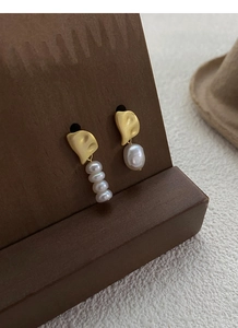 Detail of asymmetric S925 silver earrings with matte gold discs and white baroque pearls