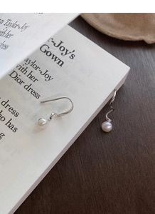 Close-up of S925 silver wavy spiral earrings featuring elegant white freshwater pearls