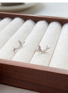 Vue détaillée des boucles d'oreilles papillon en argent 999 avec zircons dans un coffret